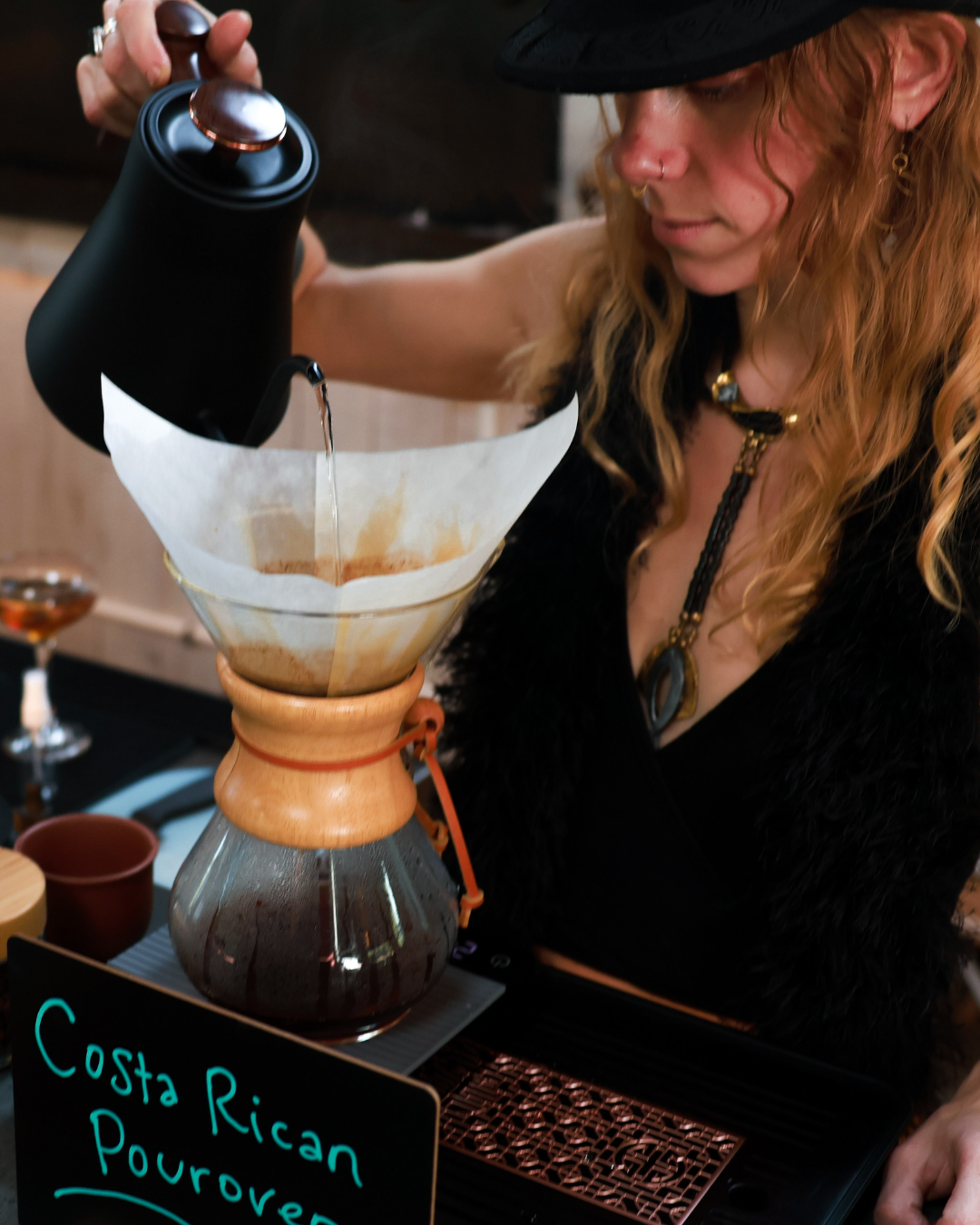 A barista pouring a botanical herbal elixir
